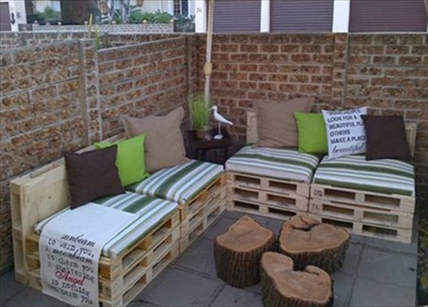 Charming-tree-trunk-coffee-table-with-wooden-pallet-couch-also-green-striped-pads-and-colorful-cushions-in-traditional-patio-design-with-bricks-wall